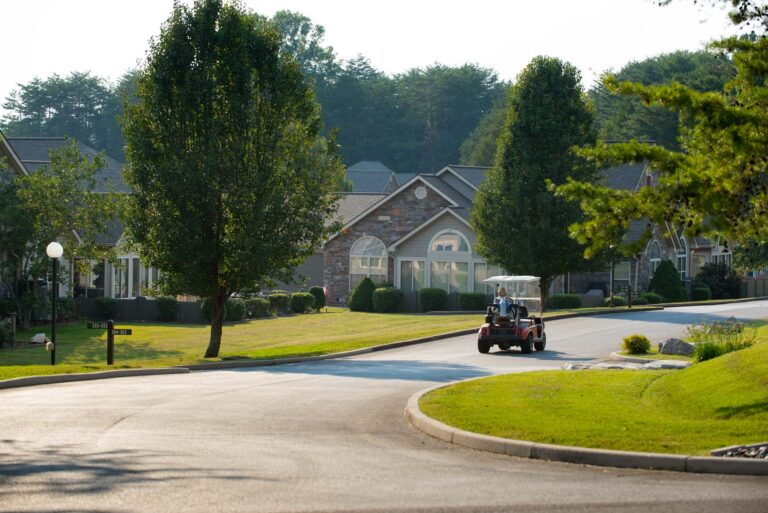 golf cart driving on street between houses