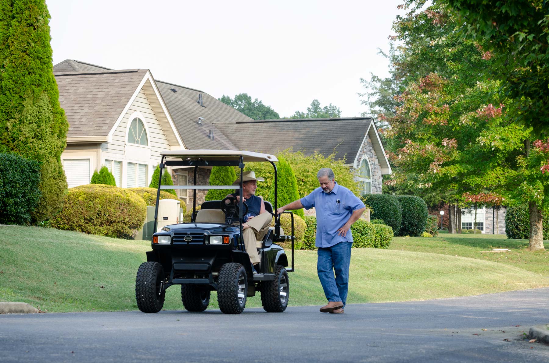 Neighbors with a golf cart chatting at The Villas at Woodson Bend.
